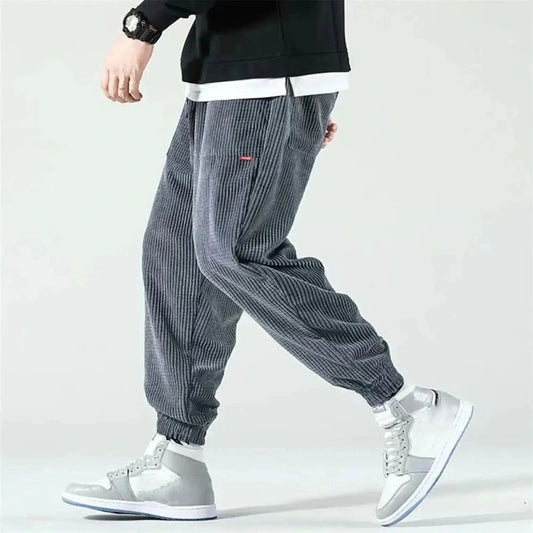 Gray corduroy joggers with elastic cuffs, worn paired with white sneakers
