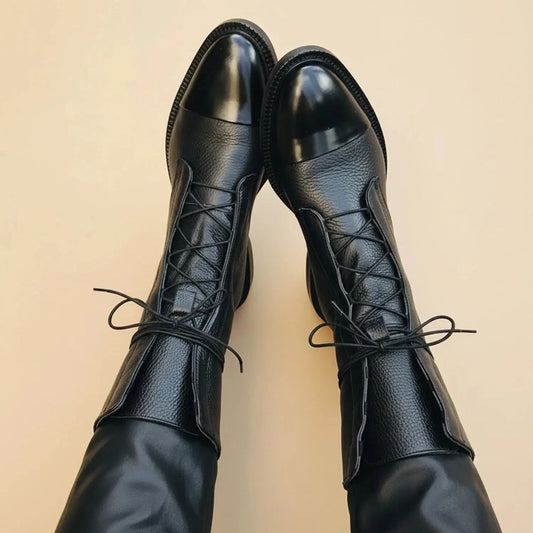 Black ankle boots with a sleek minimalist design, featuring a smooth leather exterior and a rounded toe, view