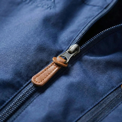 View of a dark green water repellent outdoor jacket featuring a zippered and adjustable cuffs