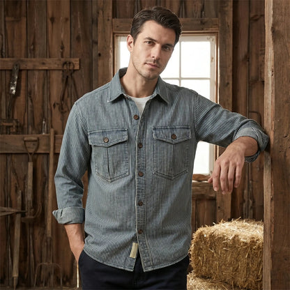 Close up of the Mens Timeless Striped Denim Shirt showing its textured fabric, precise stitching, and classic striped pattern against a neutral background.
