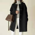 View of a charcoal gray winter coat with a minimalist design, featuring a sleek silhouette and button closure