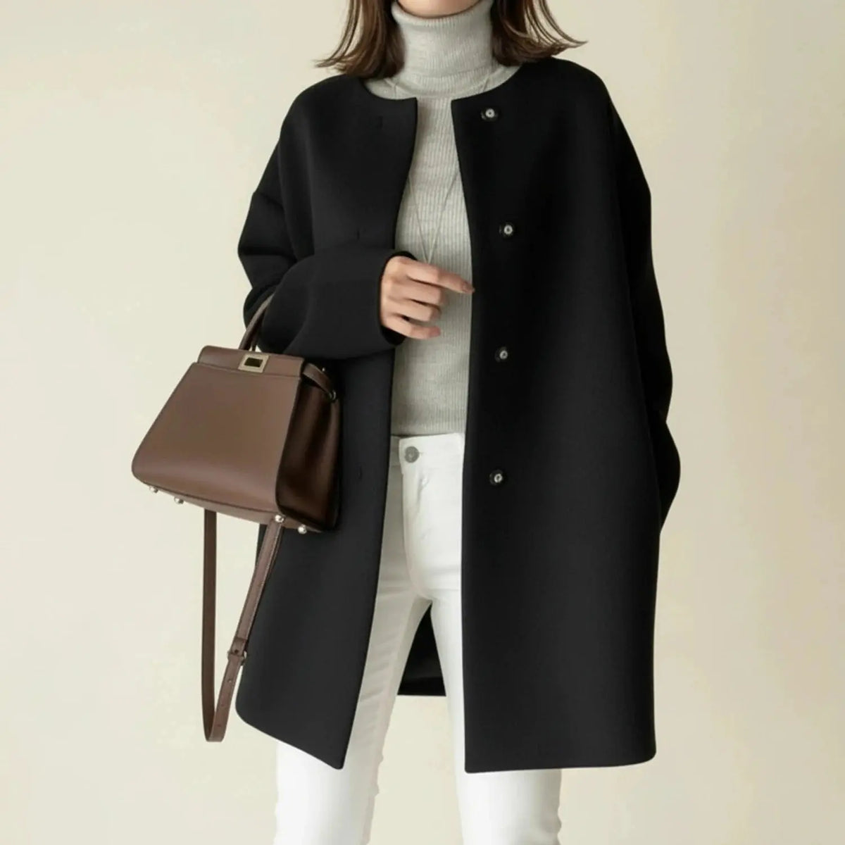 View of a charcoal gray winter coat with a minimalist design, featuring a sleek silhouette and button closure