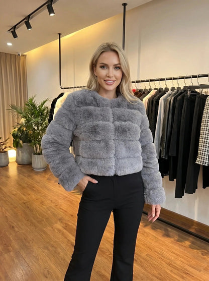 View of a luxurious fluffy autumn coat in soft beige, featuring a high collar and textured fabric
