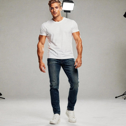 Man wearing blue jeans and white t shirt, standing confidently with hands relaxed, lighting behind