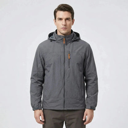 View of a men's outdoor jacket in dark green, featuring water repellent material, adjustable cuffs, and a high collar