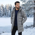 A male model showcases a sleek navy blue mens modern longline quilted winter jacket, styled with casual winter attire against a neutral backdrop.