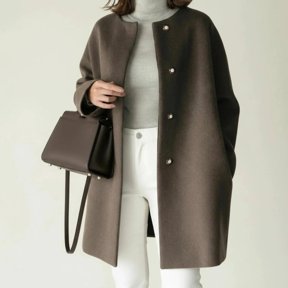 View of an elegant minimalist winter coat in deep charcoal gray, featuring a tailored silhouette and a mid length cut